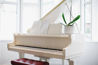 Beautiful white grand piano in bright, sunlit living room